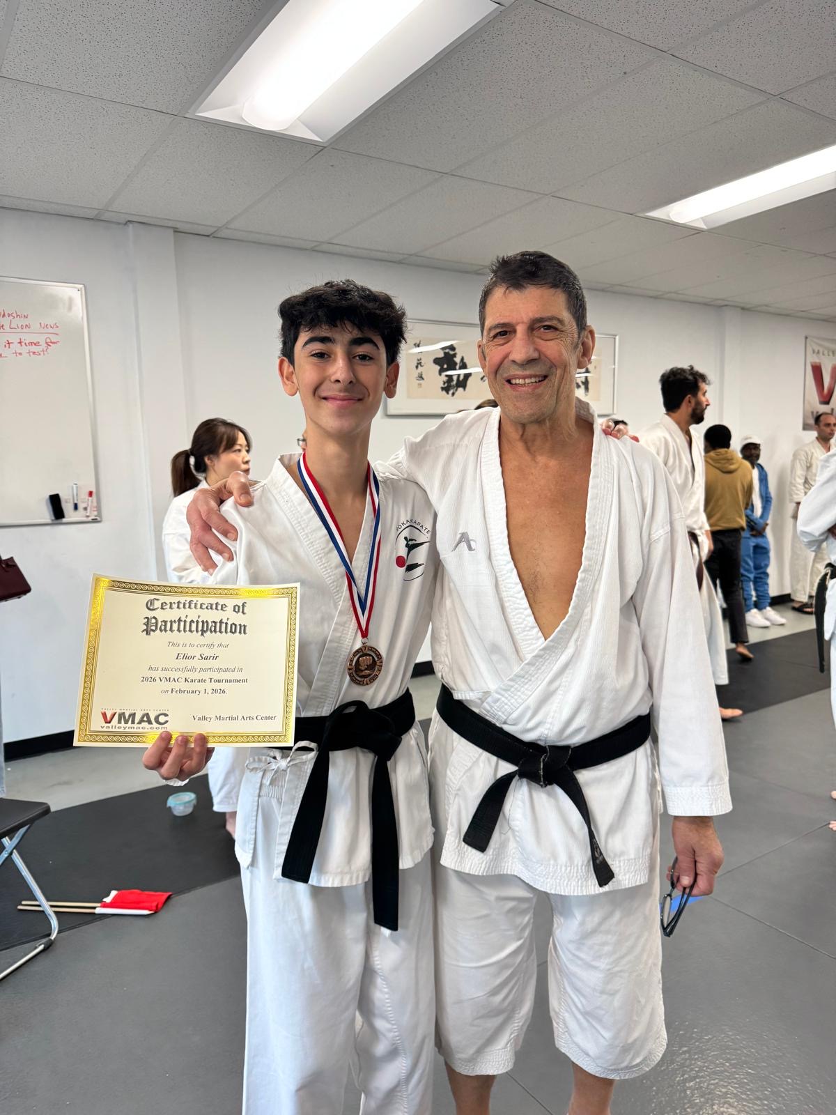 Rokah Karate teen with tournament certificate alongside Sensei Avi