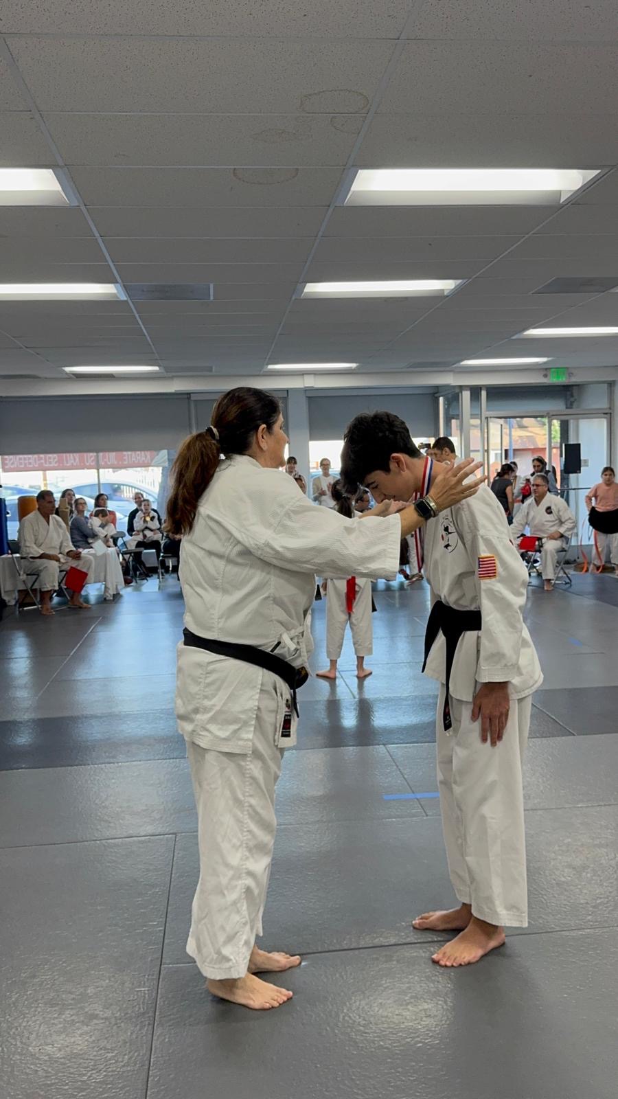 Sensei Ruth presenting a medal to a Rokah Karate teen